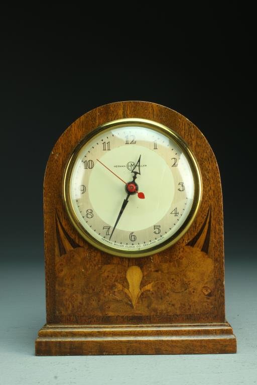Herman Miller Art Deco Walnut & Burl Electric Clock: Having a inlaid burl wood design with a glass covered face marked "Herman Miller Clock Co., Zeeland, Mich", measures 7"H, circa mid century. Condition, having several scratches to wood surface. We do