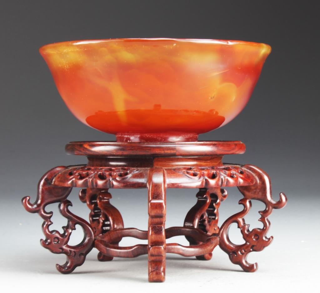 Fine Chinese Carved Carnelian Bowl: Of circular-form with slightly everted lip rim and resting on a straight foot, the stone of rich, intense color and beautifully polished, carved wooden stand, 6"D. Property of a private collector Gros