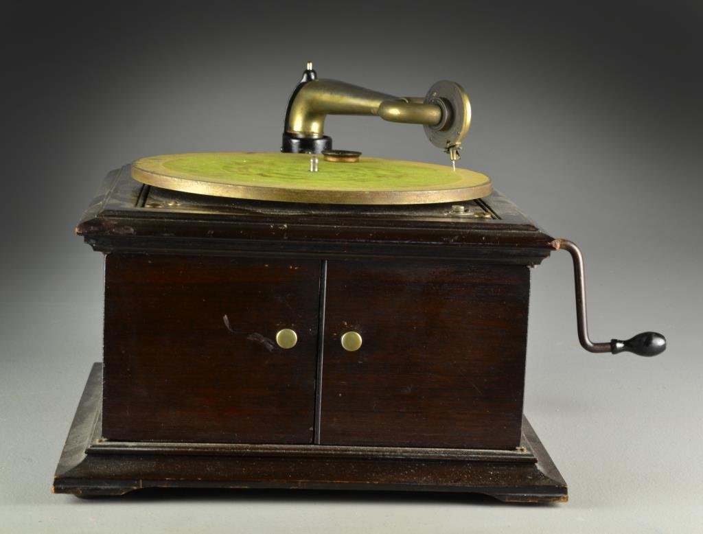 An Antique Victor Victrola Record Player: To include a Victor Victrola record player serial number 590427 with two doors opening to reveal a shelved interior for storage of records, measures 12"H X 15.25"sq. From the collection of the late An