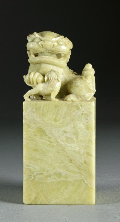 A Large Chinese Carved Soapstone Seal Chop: Finely carved to depict two foo dogs, one holding the other's tail, measures 6"H, circa late 19h-early 20th century. Condition, having chipping to one edge with loss to one ear, otherwise good overall