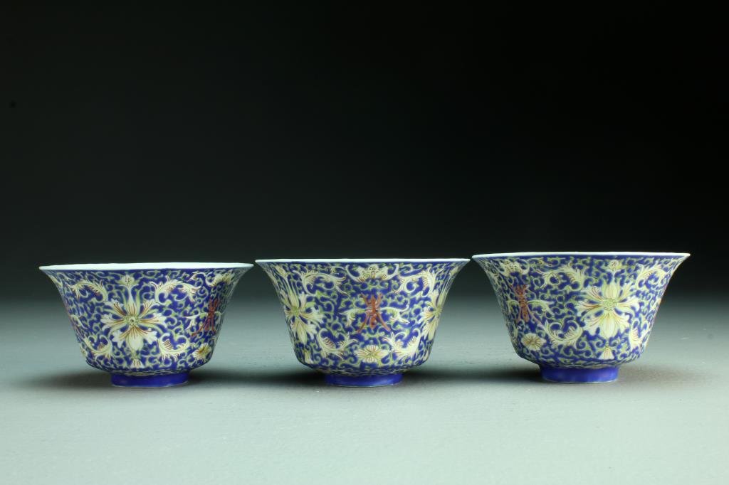 (3) Chinese Qing Famille Rose Porcelain Bowls: All having flared rims and finely enameled to depict lotus blossoms, bats, scrolling tendrils and Shou symbols, rasised on short foot rim, base with six character mark in underglaze iron red, circa la