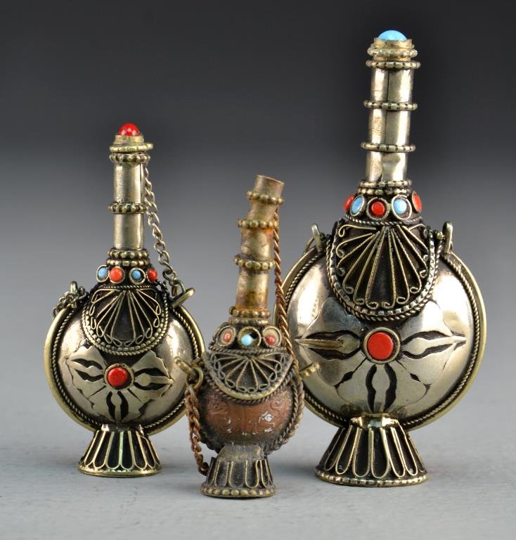 (3) Pcs Chinese Silver-Colored Metal Snuff Bottles: To include three filigree decorated snuff bottles with stoppers connected to bottles with linked chains and inset with semi-precious stones, largest measures 3.25"H. Property of a Beverly Hills, Michi