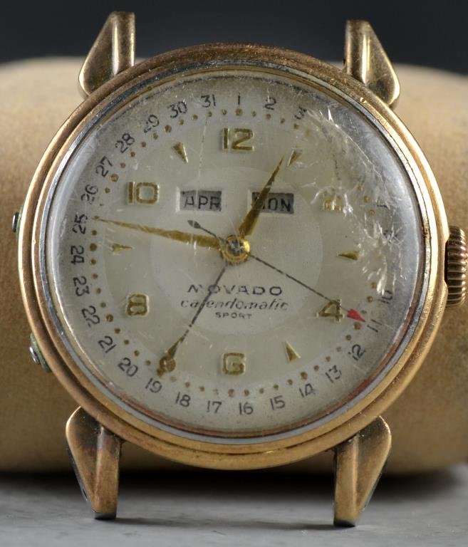 A Movado Calendomatic Sport Watch: Probably mid century, having a day and date, measures 1.375"D, circa early-mid 20th century. Condition, not working, lacking band, face with numerous scratches.