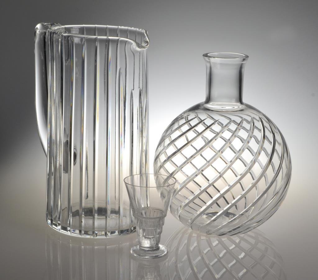 (3) Pcs Glass Inc. Baccarat and Lalique: To include a Baccarat ribbed pitcher, a Baccarat bulbous vase, and a Lilique art deco shot glass, largest measures 8.5" H, circa 20th century. Condition, excellent. Private collection of a Metamora, M