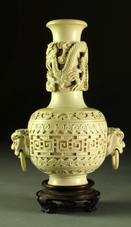 A Finely Carved Chinese Two Piece Ivory Vase: The neck having deep relief carving depicting a dragon, the body with ruyi clouds and Greek key motif, having two mythical beast handles hung with loose rings, a three character seal mark is carved to