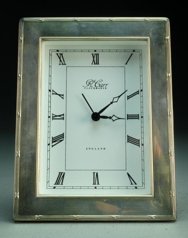 R. Carr English Sterling Shelf Clock: Rectangular shape with reeded and embossed edge, roman numerals, stamped hallmarks to outer edge, 6.5"H, circa 20th century. We do not guarantee working order of clock at time of sale