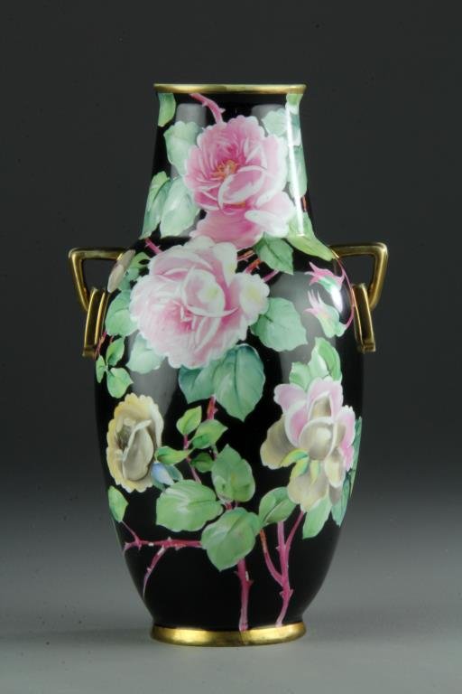Nippon Famille Noire Porcelain Vase: Finely painted to depict pink roses on the stems, with two gilt handles with simulated loose rings, with gilt rim and foot ring, base bears green Nippon mark, 13"H. Private collection South Lyon, Mich