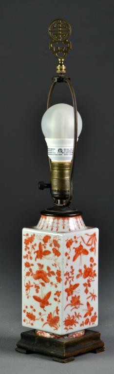 A Chinese Qing Iron Red Porcelain Vase: Of archaic form decorated with butterflies, flowers and bats in iron red, having Shou symbol finial, raised on fitted stepped wood base, later mounted as lamp, measures 19.25"H to top of finial, circa