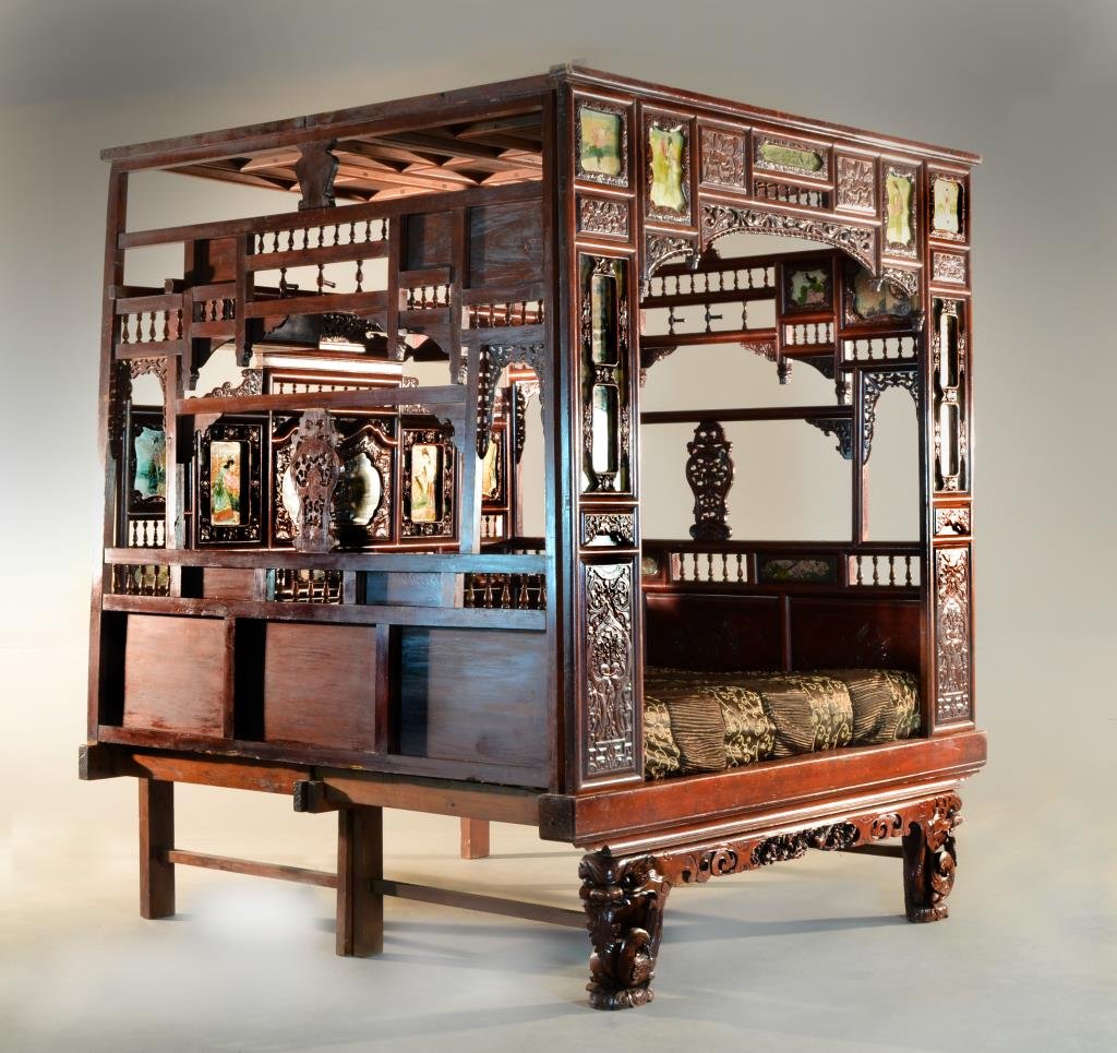 Chinese Qing Hardwood Opium Bed: The bed finley carved with lotus blossoms and tendrils, inlaid with 11 painted porcelain plaques, and two paintings on silk, the interior with cartouche shaped mirror, and several bird and lotus carvi