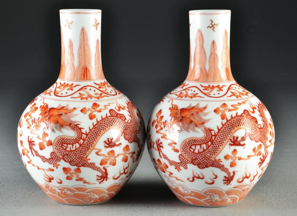 Pr. Chinese Iron Red & White Porcelain Vases: Finely painted to depict five-clawed dragons amongst ruyi clouds playing with flaming pearls, raised on short foot ring, base having six character Guangxu mark in iron red underglaze, 6.75"H, circa la