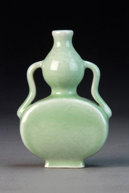 Chinese Celedon Porcelain Flask: Depicting dragons amongst ruyi clouds, base bearing seal mark in underglaze blue, 6.75"H. Condition: Stress crack to each side of body, possibly in glaze.