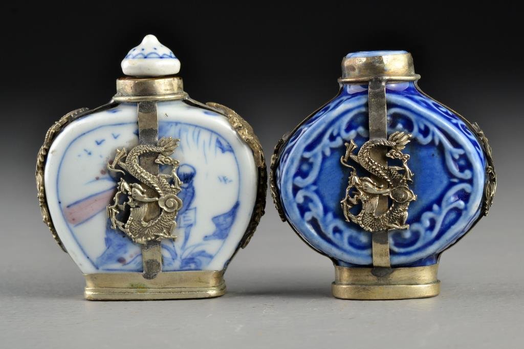 (2) Chinese Porcelain Snuff Bottles: To include a blue and white porcelain example, both having metal encasements with depictions of four clawed dragons and phoenix, bases stamped with two character mark and one an additional seal, talle