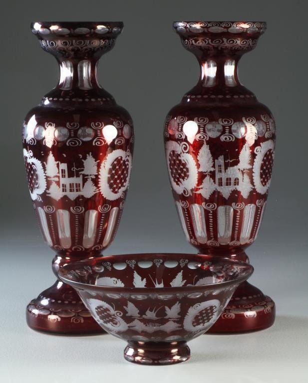 (3) Pc Antique Cranberry Cut to Clear Garniture: Having two vases and a centerpiece bowl carved to depict winter scenes with birds and wreaths, vases measure 16.75"H, circa late 19th-early 20th century. Property of a Birmingham, MI family.