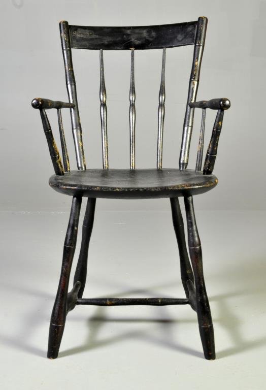 An American Black Painted Fan Backed Windsor Chair: Having bamboo turned spindles, a deeply carved saddle seat and boldly turned stretchers, having an old if not original black painted surface, measures 35"H x 20.25"W x 15"D, circa early-mid 19th centu