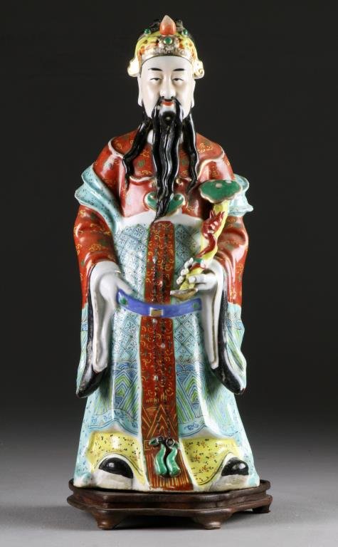 Chinese Qing Famille Rose Porcelain Figure: Molded to depict a scholar holding a ruyi scepter, having an impressed oval seal mark to underside, raised on carved hardwood stand, figure measures 17"H, circa late 19th-early 20th century. Property 