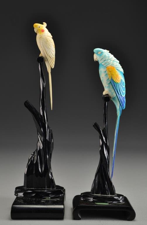 Pr. Japanese Carved Ivory & Polycrhome Painted Parrots: Finely carved and polychrome painted depicting two perched parrots on carved wood display stands, largest parrot measures 9"L, largest overall measures 13.5"H. Condition: Larger parrot lacking head co