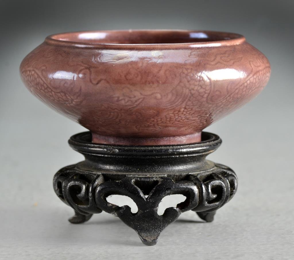 A Chinese Ming Chenghua Marked Porcelain Brush Wash: Having incised dragons against a plum ground, having a six character mark within a circle in underglaze blue, raised on carved hardwood stand, measures 3.25"Dia.