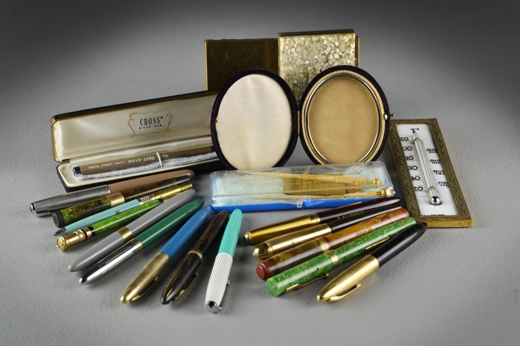 A Grouping of (15+) Pens & Assorted Items: To include sixteen assorted ink pens including names Cross, Waterman's and Swan, along with a German thermometer, two brass cases, a miniature velour cased picture frame and two hand carved gilt-tippe