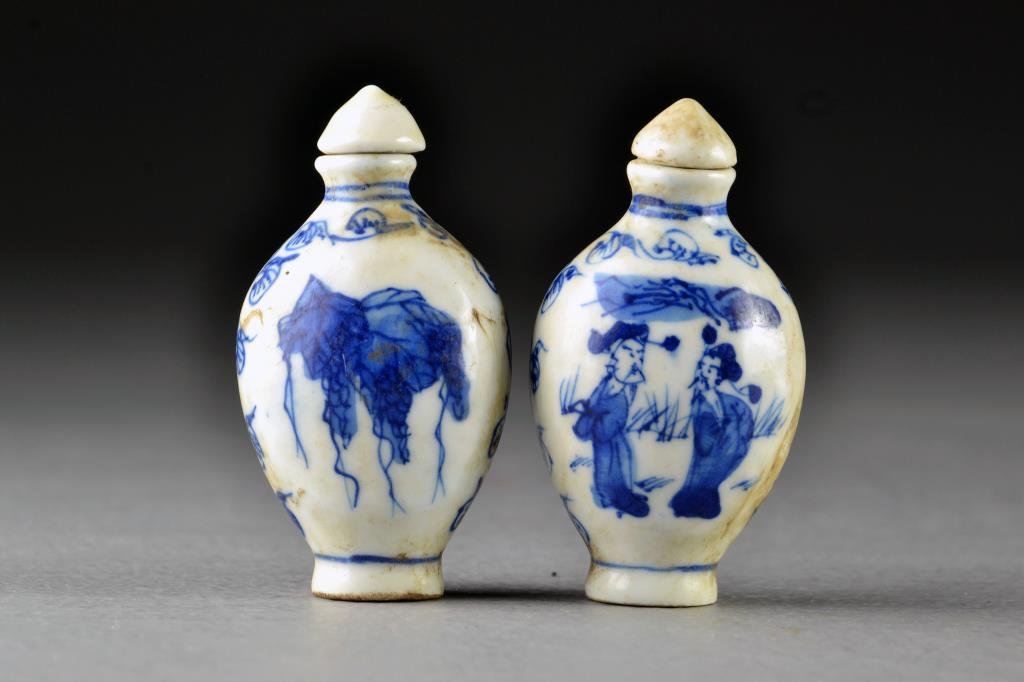 (2) Chinese Blue and White Porcelain Snuff Bottles: Finely painted at center to depict bunches of grapes, a cricket and figures in a landscape, each having scrolling border design, bases marked by leaf in underglaze blue, both measure 2.7"H.