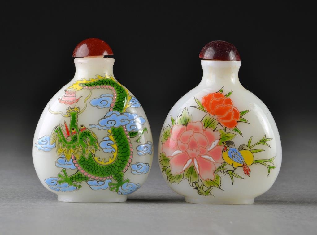 (2) Chinese Peking Glass Snuff Bottles: One finely painted to depict a phoenix and four clawed dragon among ruyi clouds, the other depicting birds among flowers and pomegranates, bases bearing four character marks in underglaze blue and iro