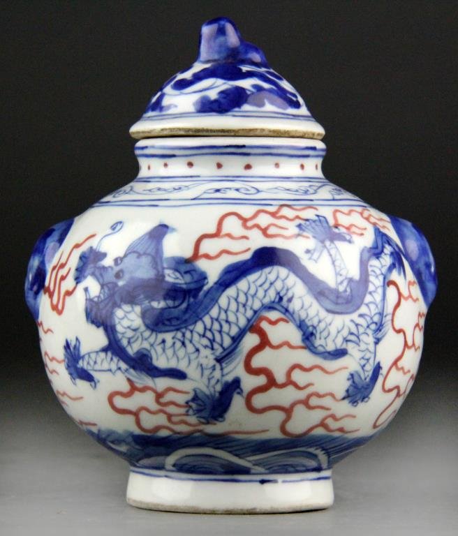 Chinese Blue/White/Red Porcelain Covered Jar: Bulbous blue and white porcelain covered jar having blue dragons and red ruyi clouds, top is has tendril decoration with dog finial, two faux handles, underglazed blue leaf mark on bottom, 5" H x 4.25