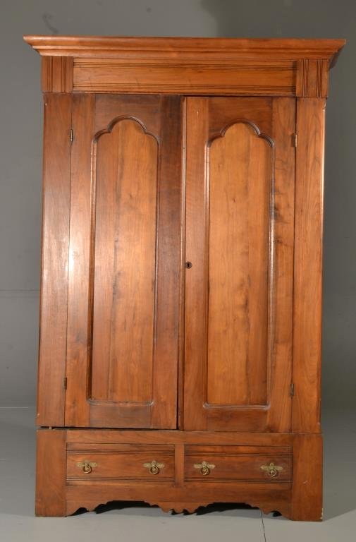 Antique Eastlake Carved Pine Wardrobe: Molded cornice above two arched paneled doors, paneled sides, the interior with four large hooks, above two dovetailed drawers with original brasses, and carved scalloped apron, 77" H x 45" W x 22" D,