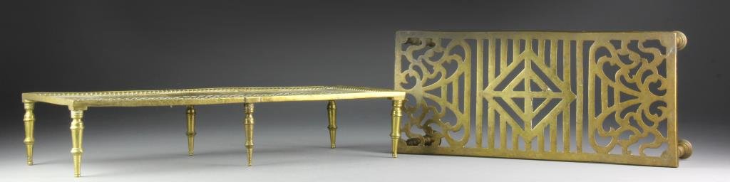 (2) English Brass Trivets: Each having pierced decoration raised on four and six feet with turned elements, largest 4"H x 20.5"L x 9"D, circa 19th century. Each having surface wear and abrasions consistent with age and use, one