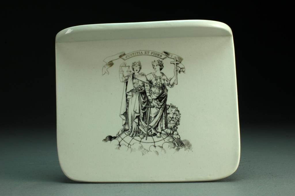 A Wedgwood Pearlware Pill Slab: Black transfer printed with figure of blind justice below a ribbon inscribed Justitia Et Fides, impressed mark for Wedgwood, measures 5.75"H x 7"W, circa early 20th century. Good condition, some light