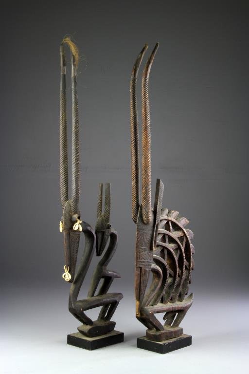 (2) Antique African Carved Wood Headdresses: To include two carved headdresses, both in the form of a gazelle or antelope, one having seashell decoration with one small figure atop the back of a larger figure, and one having leather and animal h