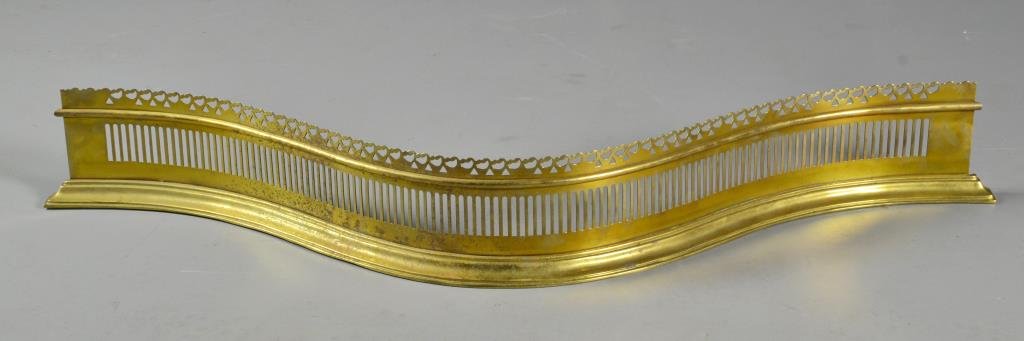 Georgian English Brass Serpentine Fire Fender: Having scalloped and pierced edge with pierced vertical stripes, stepped brass base weighted with cast iron having stamp for "Williamsburg" and "VM?" with other illegible stamp, measures 6.5"H x 50"W 