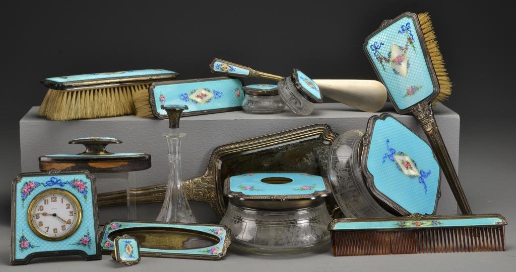 (13) Pc Sterling, Guilloché and Enamel Dresser Set: To include a large hand mirror, a large hand brush, two shoe brushes, emory board and stand, two large dresser boxes including a hair receiver, a perfume bottle, comb, shoehorn, two small dresser boxe