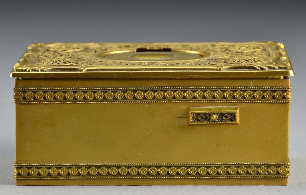 German Singing Bird Gilt Brass Music Box: Having filigree to top and bands of scrolling decoration to body, lid opens to reveal animated feathered bird, apparently unmarked, measures 1.75"H x 4.25"L x 2.75"D, circa early 20th century, needs r