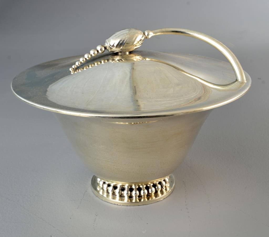 A Danish Mid-Century Silver Plate Covered Centerpiece: Having a roller bearing machined base and flower encrusted lid, apparently unmarked, measures 8"H, circa mid-20th century. Condition: having overall surface wear, interior of bowl having several scrat