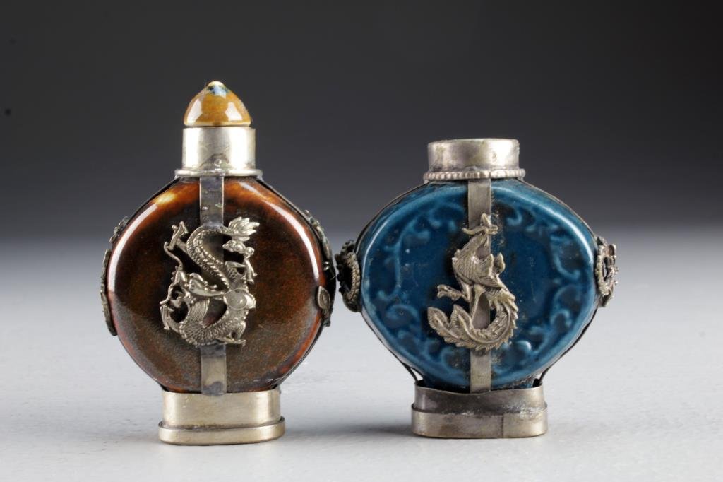 (2) Chinese Porcelain Snuff Bottles: Each having metal fixtures depicting four clawed dragons, one having phoenix to sides, seal and character mark to base, the other with beast head handles and character mark to base, tallest is 2.9"H.