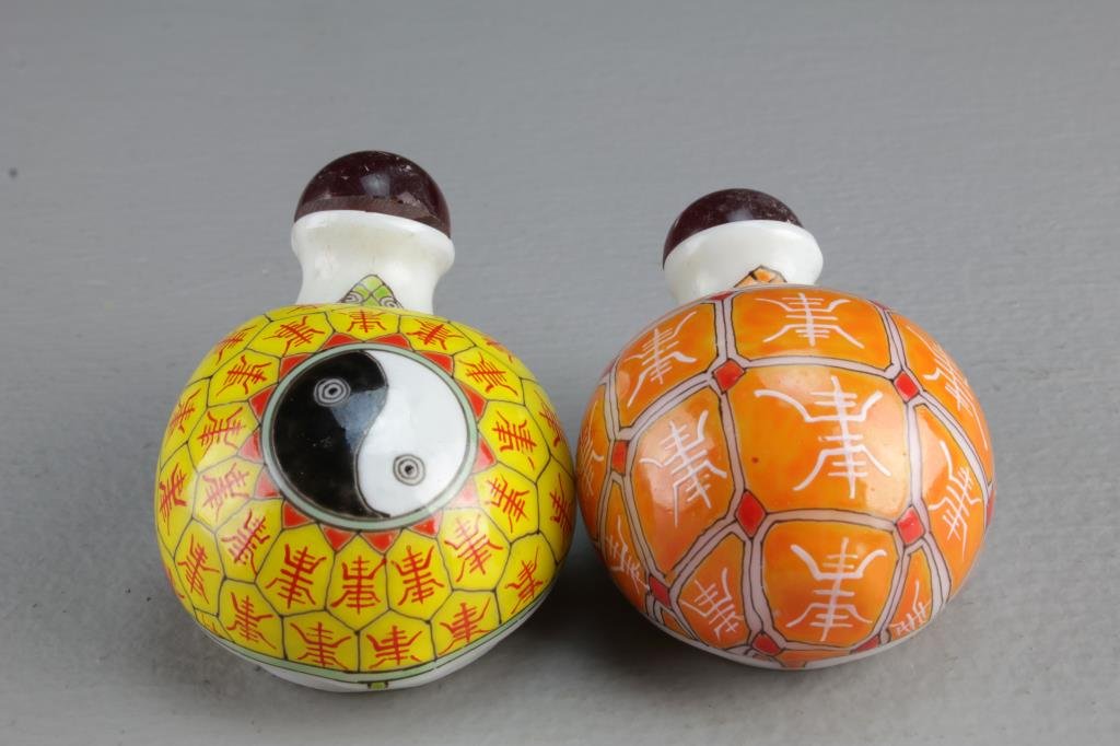 (2) Chinese Peking Glass Snuff Bottles: Each molded and painted as turtle, shells having symbols, one with yin-yang at center, four character marks in iron red and blue to bases, largest is 3.1"L.