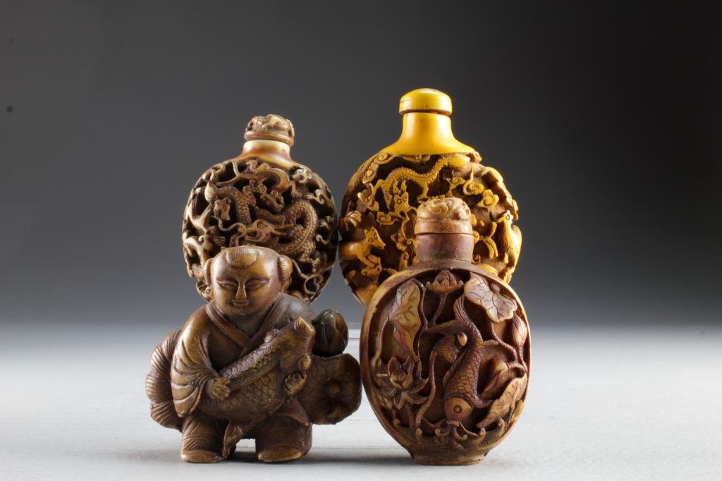 (4) Chinese Molded Snuff Bottles: To include four molded composite examples, two depicting dragons and various animals, another depicting koi fish with lotus flowers at center, fourth example formed as a standing figure holding fish,