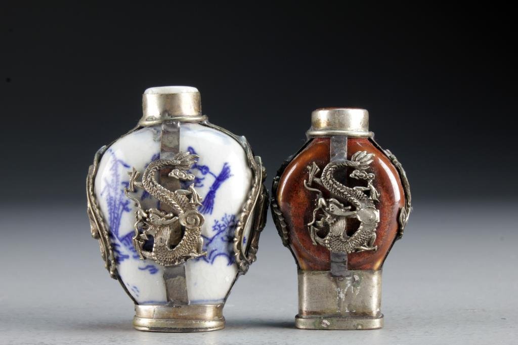 (2) Chinese Porcelain Snuff Bottles: Having decorative metal fixtures depicting four clawed dragons, phoenix and Guanyin, bases stamped with two character mark, tallest is 2.7"H.