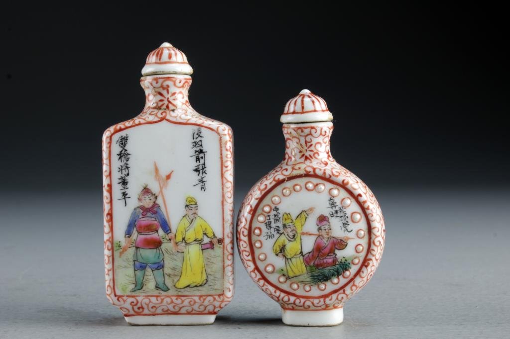 (2) Chinese Famille Rose Porcelain Snuff Bottles: Finely painted to depict figures training with weapons in landscape scenes, each having several lines of calligraphy and iron red border designs, one also having molded dot border at center, bases bea