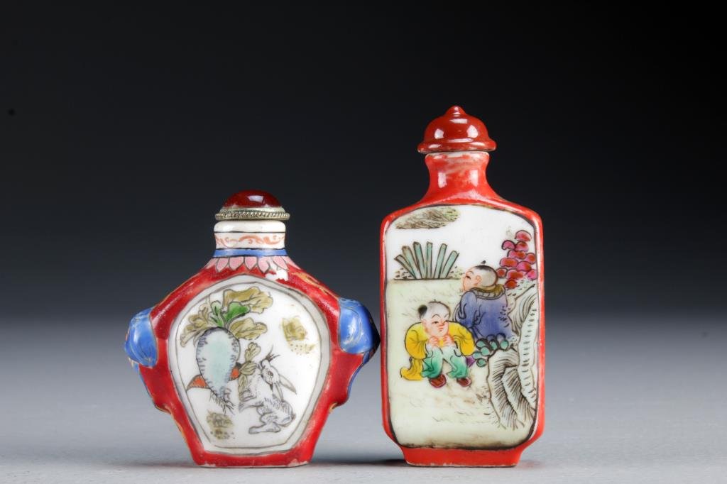 (2) Chinese Famille Rose Porcelain Snuff Bottles: One finely painted to depict playful youth in landscape scenes, the other depicting rabbit with radish and grasshopper with lettuce to the reverse side, latter having molded and painted beast head han