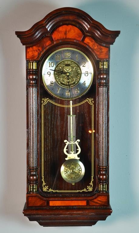 A Seiko Florian Pendulum Wall Clock: Dark brown solid oak case with hand-rubbed finish, ornamental dial, applied numerals, solid brass accents, glass crystal, Westminster/Whittington quarter-hour chime, hourly strikes, nighttime chime si