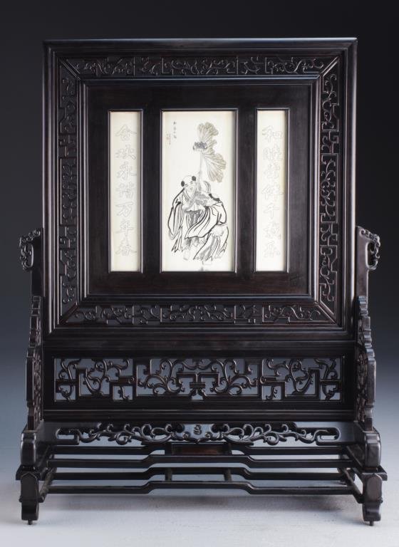 Chinese Rosewood Ivory Inlaid Table Screen: Finely carved and painted to depict He-he gods with calligraphy and seal mark upper left, flanked on either side by an additional ivory plaque with carved character marks all set in a rosewood stand, 