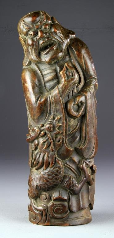 A Large Chinese Qing Carved Bamboo Lohan: Holding a peach and wine cup wrapped with a dragon, exhibiting an attractive old surface, 16.25" H, circa 19th century. Collection of the Late Robert Willis owner of R.F. Willis Galleries, Grand Rapid