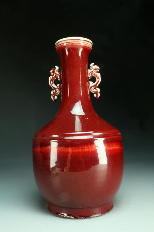 Chinese Sang de Boeuf Porcelain Vase: Having a deep ox blood glaze, a chilong handle adorns each side, raised on pronounced foot, 16.25"H. Condition: Some chipping to foot.