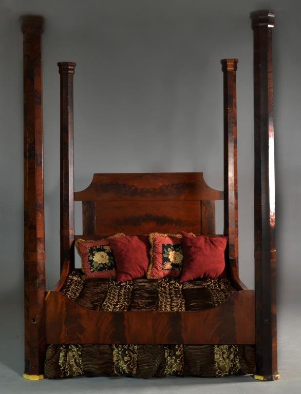Flame Mahogany Four Poster Bed: Having large octagonal columns and a shaped headboard and footboard, measures 93"H x 66"W x 83"D, headboard measures 53"H, circa late 19th century. Condition: having multiple areas of veneer loss, all