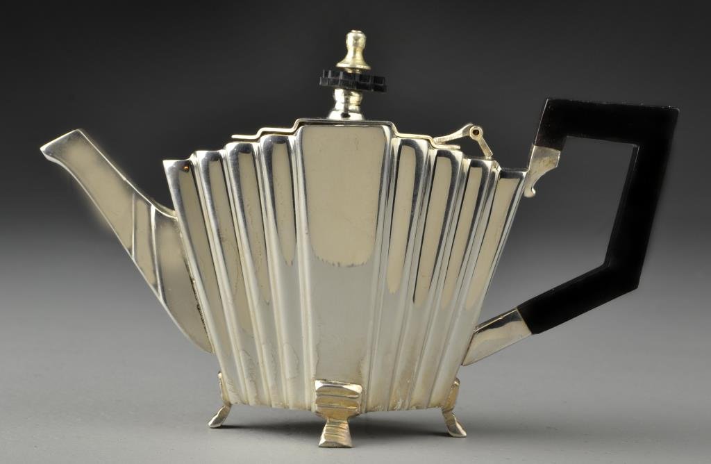 An Art Deco Silver Plated Teapot: Having a three dimensional panel design, ebonized wood handle and raised on four feet, 5.5"H to top of finial, circa early to mid 20th century. Condition, having light overall wear to handle otherwise