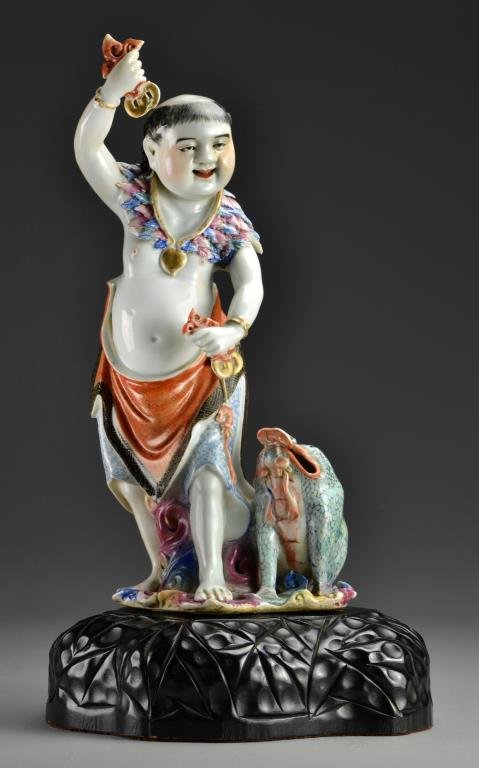 A Fine & Large Chinese Republic Porcelain Figure: Exquisitely rendered and painted with vibrant colors to depict Lui Hai and his three legged toad standing atop crashing waves, holding in his hands coins hung from red cord and wearing colorful leaves
