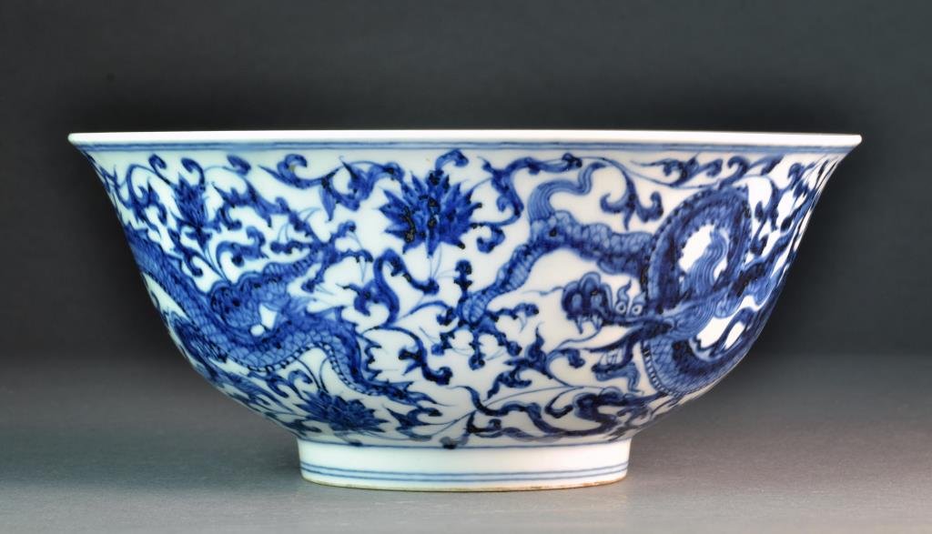 A Chinese Blue & White Porcelain Bowl: Depicting five clawed dragon among ruyi clouds to center interior, exterior with dragons, lotus flowers and scrolling tendrils, six character mark to base within two concentric circles, done in underg
