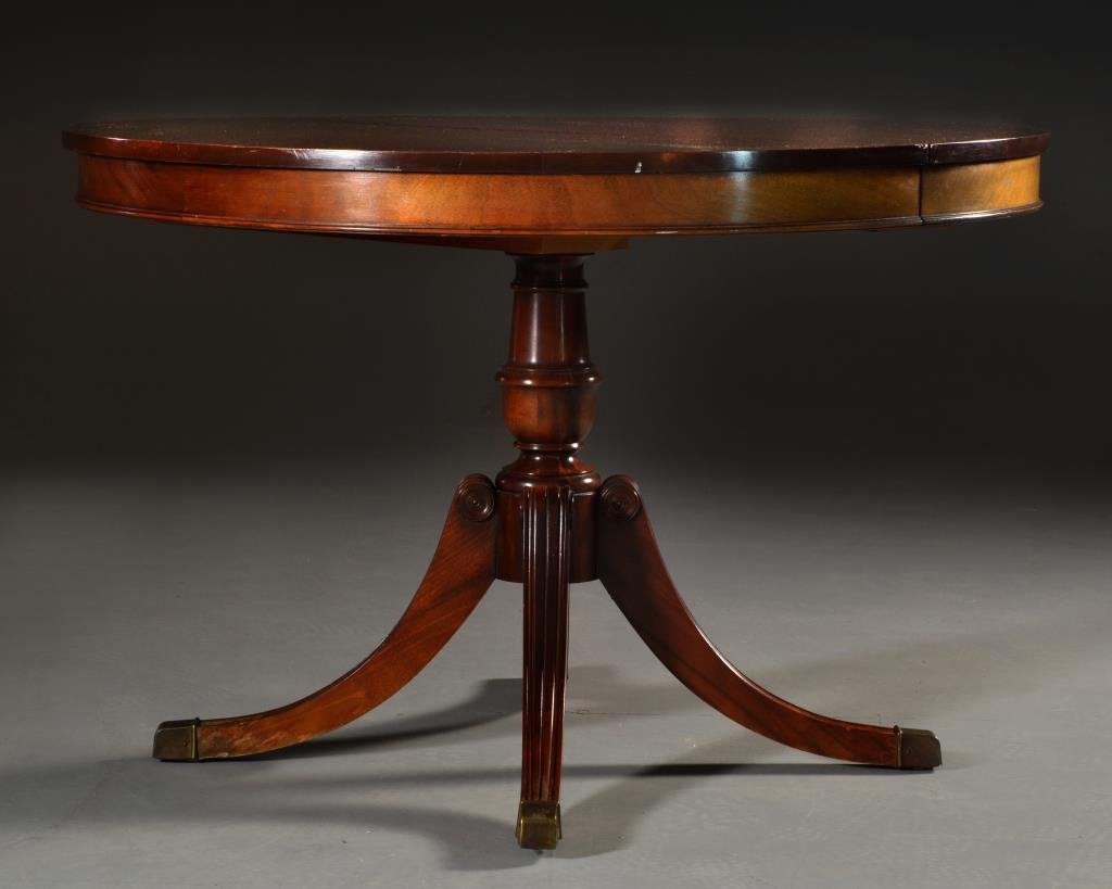 Drexel Mahogany Duncan Phyfe Style Dining Table: Having a circular top over four reeded and splayed legs with brass caps, measures 29.5"H x 44"Dia (64"L fully extended), includes two 12"W leafs, circa mid 20th century. Condition: all over surface we
