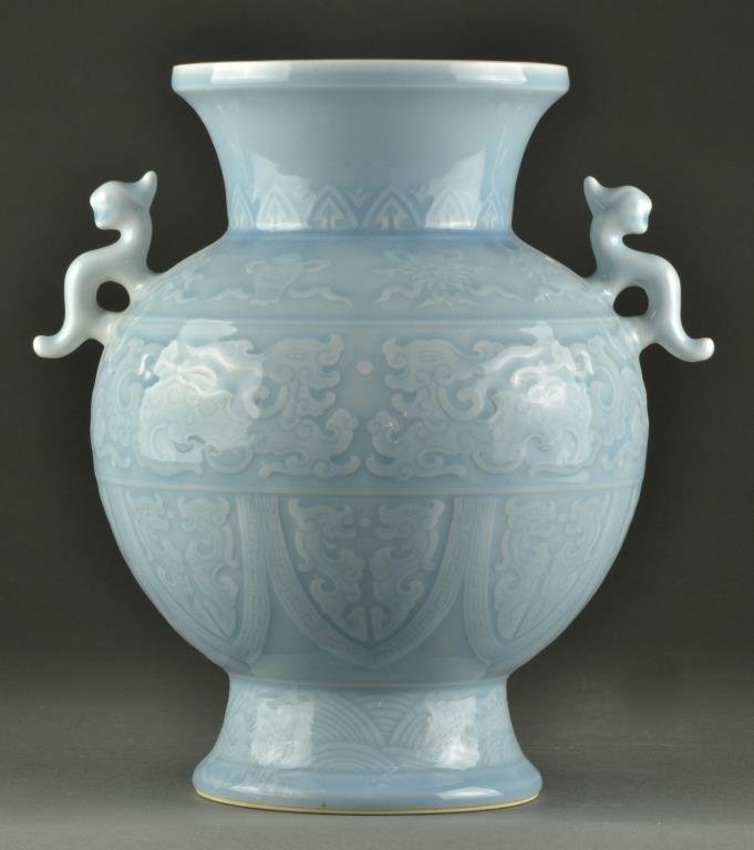 A Chinese Clair de Lune Porcelain Vase: Finished in a Clair de Lune glaze, body molded with depictions of various antiques, fish, beasts, crashing waves and bands of the Greek key design, with figural handles, base marked by a blue seal und