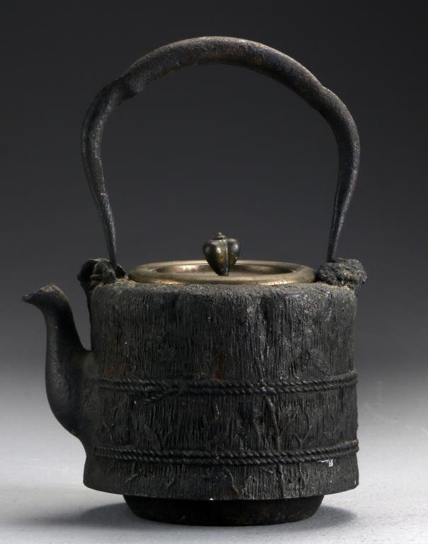 A Japanese Meiji Cast Iron Teapot: Formed as a bail of hay wrapped with formed rope, the copper lid having a line of calligraphy to the interior, 8.5"H including the handle, circa Meiji Period. Property of a Lapeer, MI couple.